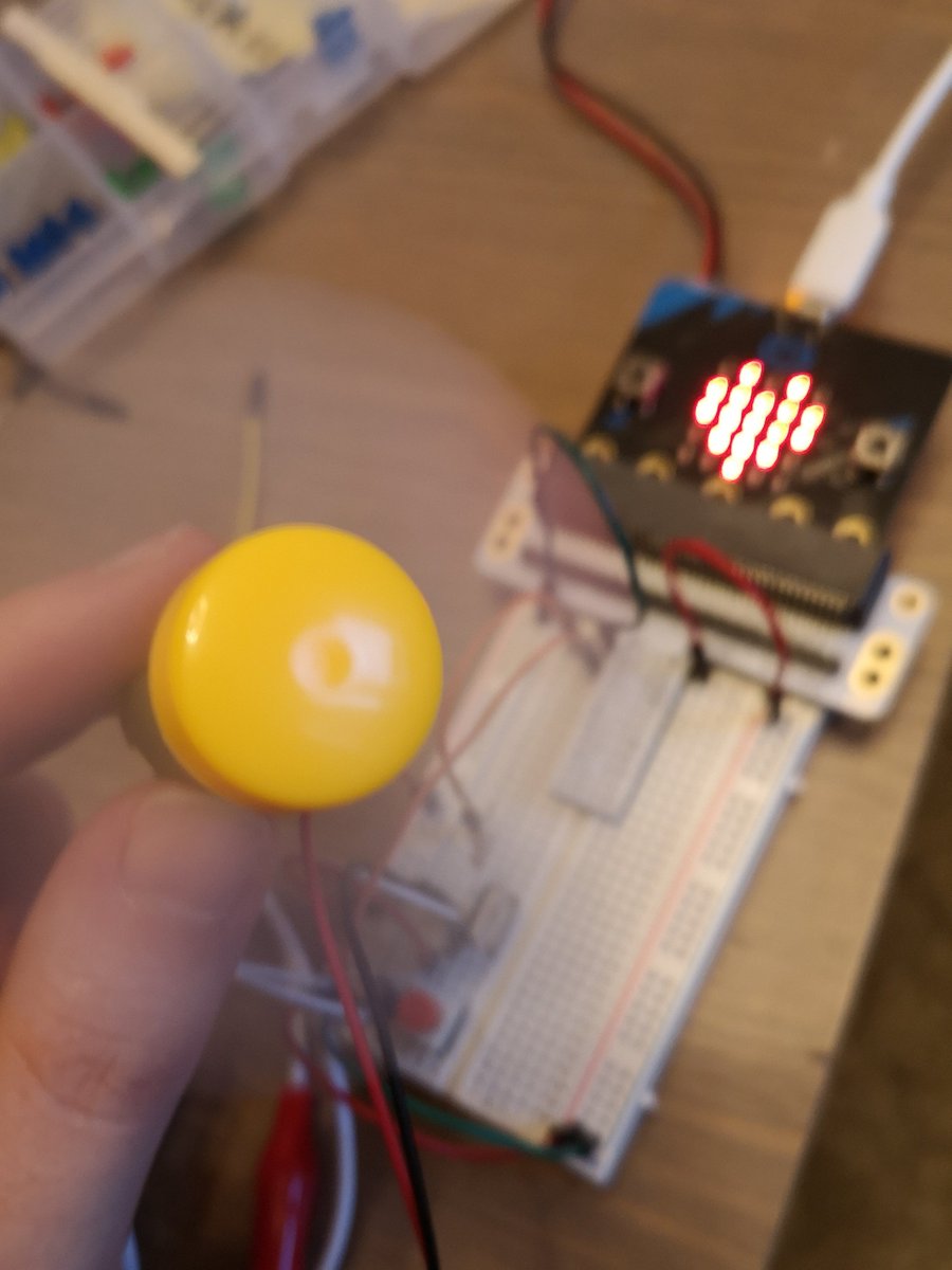 Microbit circuit that has a button and controls a fan. A spinning fan is shown on the foreground